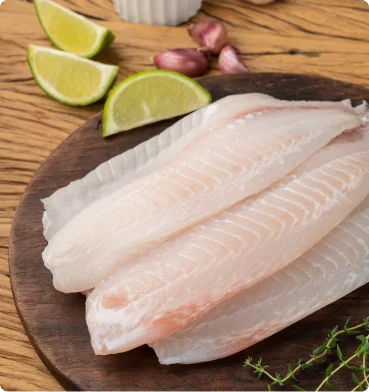raw white fish fillets on cutting board