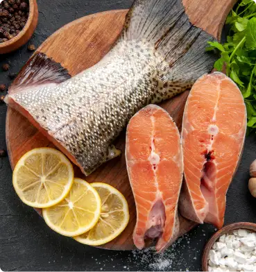 Pescado entero y cortes de salmón sobre tabla